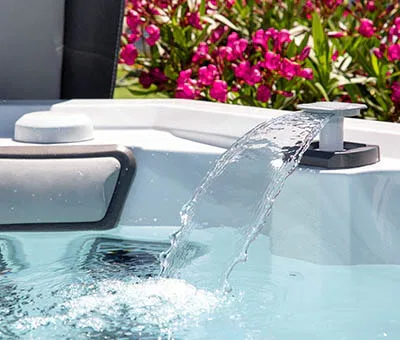 cascading high-pressure water jet in an individual therapeutic spa outdoor hot tub being filled up